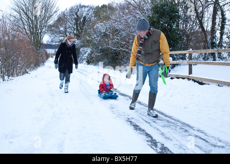 Junge auf einem Schlitten im Schnee, Hattingley, Hampshire, England, Vereinigtes Königreich gezogen wird. Stockfoto