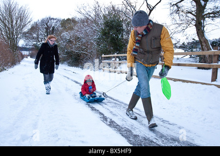 Junge auf einem Schlitten im Schnee, Hattingley, Hampshire, England, Vereinigtes Königreich gezogen wird. Stockfoto