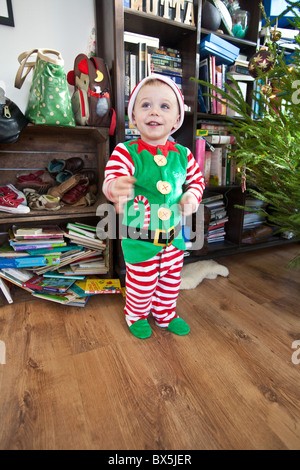 Ein Jahr alter Junge verkleidet als ein Weihnachtself, Santa es little Helper. Hampshire, England, Vereinigtes Königreich. Stockfoto