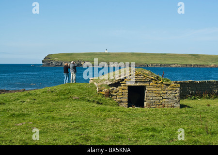 dh Brough of Birsay BIRSAY ORKNEY paar touristische Besucher Seevögeln Bucht von Birsay Fernglas betrachten Stockfoto