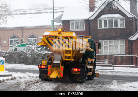 Verbreitung von Splitt oder Salz über eine Vorstadt Straße in South London während eines Schneesturms abstumpfender LKW Stockfoto