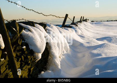 Schnee driftet auf einer Trockenmauer auf Brown Knoll, in der Nähe von Hayfield, Peak District, Derbyshire, England, UK Stockfoto