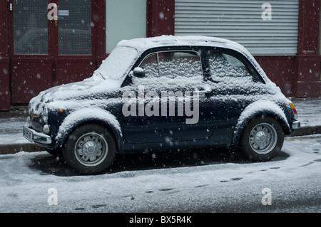 Fiat Kleinwagen bedeckt mit Schnee in einer Paris Straße. Stockfoto