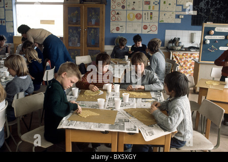 Archiv historisches Bild der Grundschule Unterricht mit 7 Jahre alten Kindern schaffen Bilder mit Makkaroni und Kleber Stockfoto