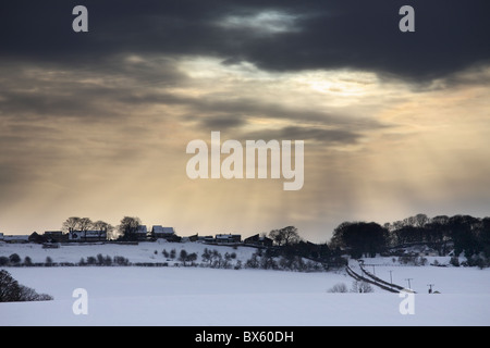 Licht bricht durch die Wolken über dem Schnee bedeckt Landschaft. Offerton, in der Nähe von Sunderland, Tyne and Wear, England, UK Stockfoto