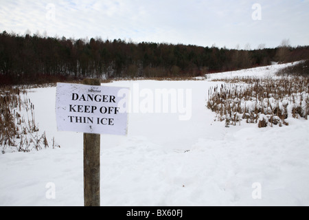 Ein Schild mit der Aufschrift Gefahr zu halten aus dünnem Eis, James Steel park, Washington, England, UK Stockfoto