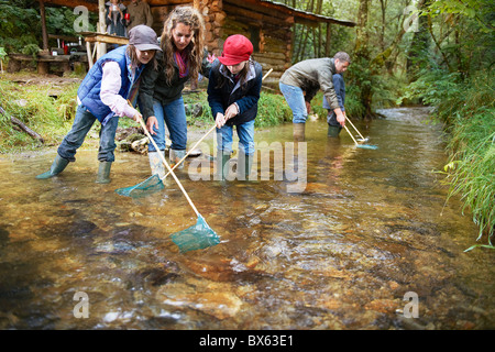 Familie Fischen mit Netzen in einem Fluss Stockfoto