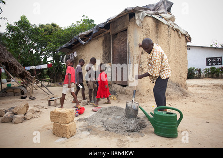 Ein Mann baut ein Haus in Kakata, Liberia, Westafrika. Stockfoto