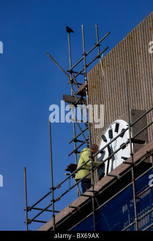 Ein Mann stellt eine Uhr auf der Seite Hove Rathaus, Hove, East Sussex, UK. Stockfoto