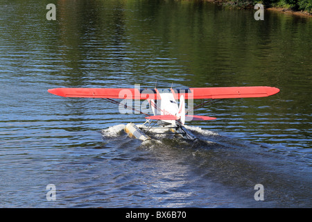 Schweben Sie Flugzeug oder Wasserflugzeug nehmen Flug zu reisen, an einem Fluss in Alaska, USA fliegen Stockfoto