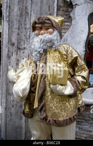 Santa Claus Marionette goldenen Kleid mit Weihnachten Geschenke Weihnachten in den Händen Feier Festlichkeit Straße Stadt Stockfoto