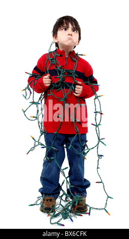 Sechs Jahre alter Junge mit verworrenen Weihnachtsbaums. Stockfoto