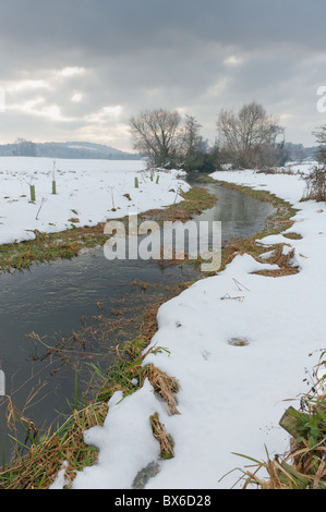 bedrohliche Schneewolken am Himmel überschatten die bitterkalte Fluß Darent Stockfoto