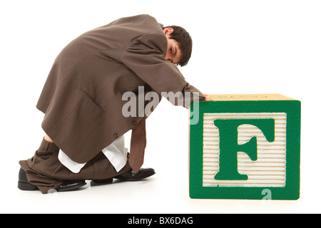 Entzückende junge im großen Anzug riesigen Buchstaben F Alphabet Block schieben. Stockfoto