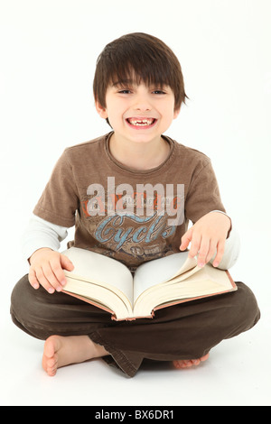 Liebenswert sieben Jahre alten französischen amerikanischer Junge mit Buch auf weißem Hintergrund. Stockfoto