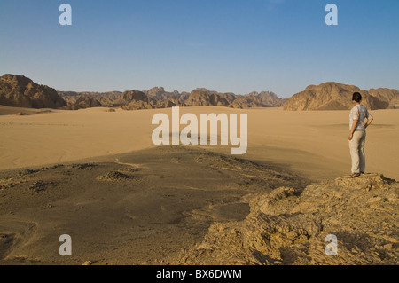 Frau bewundert die große Wüstenlandschaft der Sahara, in der Nähe von Djanet, Algerien, Nordafrika, Afrika Stockfoto