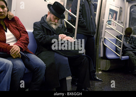 Müde orthodoxer Jude Fahrten mit die u-Bahn von Manhattan nach Hause nach Brooklyn. Stockfoto