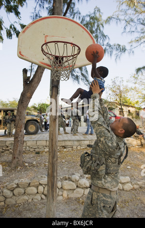 US Armee-Soldat spielen Basketball in einem Waisenhaus in Port-au-Prince nach dem Erdbeben 2010, Port au Prince, Haiti Stockfoto