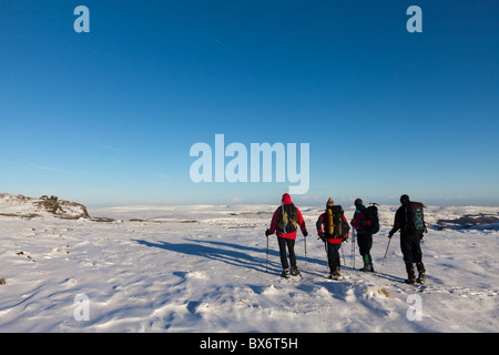 Wanderer im Winter auf Kinder Scout im Peak District National Park, mit Blick auf Bleaklow von Fairbrook Naze Derbyshire Stockfoto