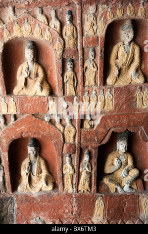 Schnitzereien von Buddha auf einer Wand im Inneren der alten Yungang Grotten, Datong, Shanxi, China. Stockfoto