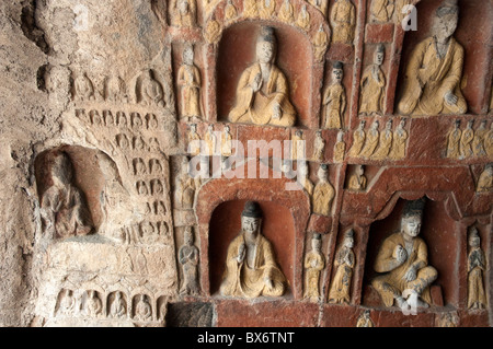 Schnitzereien von Buddha auf einer Wand im Inneren der alten Yungang Grotten, Datong, Shanxi, China. Stockfoto