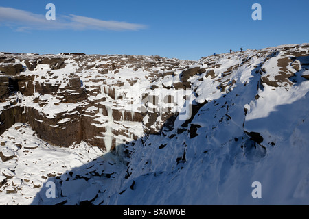 Wanderer über einen gefrorenen Kinder Untergang im Dunkeln Peak Teil der Peak District National Park, Derbyshire, UK Stockfoto