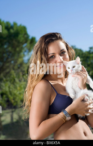 Junge Frau hält weiße Kätzchen außerhalb Stockfoto