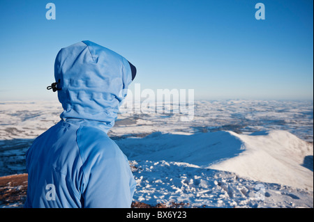 Wanderer auf der Suche durch Winterlandschaft vom Gipfel des Pen Y Fan, Brecon Beacons National Park, Wales Stockfoto