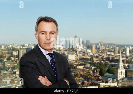 Porträt von Executive mit Blick auf Stadtlandschaft hinter ihm Stockfoto