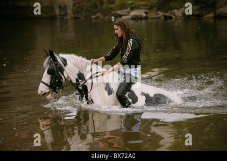 Fahrende Reiten und Waschen ein Pferd in den Fluss Eden während der Appleby Horse Fair, Appleby in Westmorland, Cumbria, UK Stockfoto