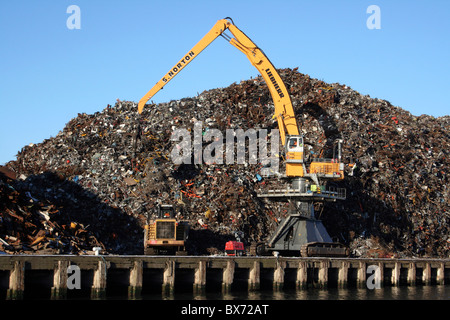 Kran steht neben einem Haufen Schrott in Liverpool Docks, UK Stockfoto