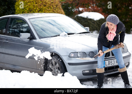 Frau aus dem Auto aus dem Schnee Graben Stockfoto