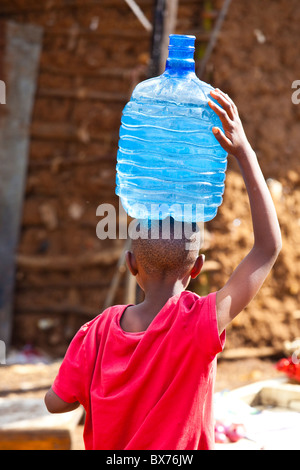 Junge Wassertragen in Kibera Slum, Nairobi, Kenia Stockfoto