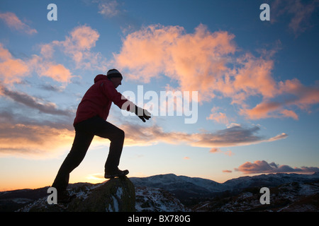 Ein Bergsteiger auf Todd Crag Gipfel im Lake District, Großbritannien, in der Dämmerung. Stockfoto