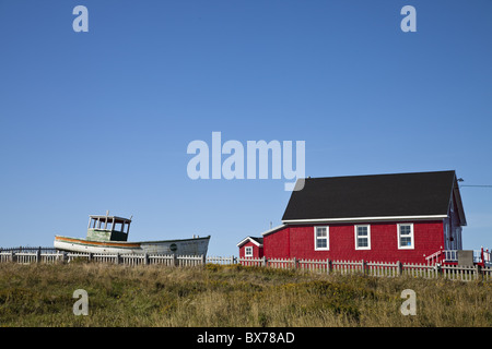 Maritime Haus mit Boot auf Rasen, Iles De La Madeleine (Magdalen Islands), St.-Lorenz-Golf, Quebec, Kanada rot lackiert Stockfoto