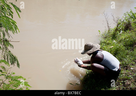 Eine Frau macht ihre Wäsche im Fluss Artibonite, die Quelle von dem jüngsten Choleraausbruch, Stockfoto