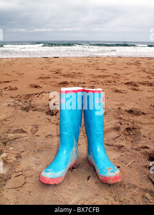 Paar von farbigen Wellington Stiefel am Strand Stockfoto