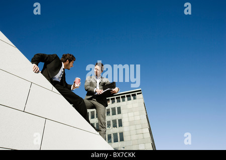 Männer, die das Geschäft auf Dach Stockfoto
