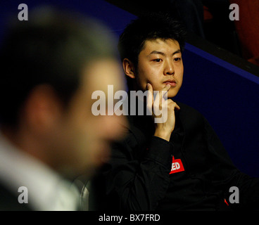 Liang Wenbo von China im Kampf gegen Ronnie OSullivan von England, während der 1. Runde der Snooker-Weltmeister Betfred Stockfoto