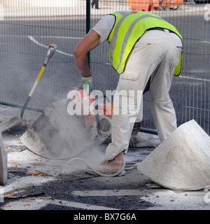 Arbeiter mit tragbaren Mauerwerk sah Kerb Steinen geschnitten Stockfoto