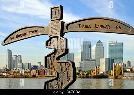 Riverside Promenade Wegweiser auf Greenwich Peninsula ist auch Teil des National Cycle Network mit Canary Wharf Skyline über Stockfoto