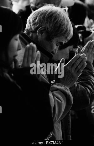 Porträt von Mann und Frau beten während des Neujahrsfestes am Meiji Jingu Schrein, Tokyo, japan Stockfoto