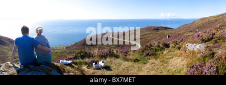 Ein junges Paar genießt die Aussicht von der Mull of Kintyre, Argyll & Bute, Schottland, Großbritannien - Islay und Jura sind im Hintergrund zu sehen Stockfoto