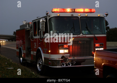 Ein Feuerwehrauto mit San Diego Feuerwehr beantwortet einen Anruf Tto helfen bei der Rettung eines Opfers aus dem Auto geworfen. Stockfoto