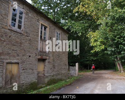 Camino de Santiago-Pilger zu Fuß durch ländliches Dorf. Stockfoto