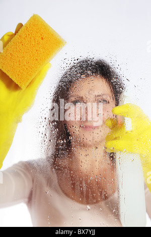 Attraktive junge Frau, die Reinigung von Fenstern. Alle isoliert auf weißem Hintergrund. Stockfoto