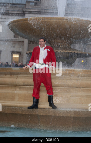 Als Weihnachtsmann verkleidet Santacon 2010, Flashmob Zusammenkunft von Menschen im Zentrum von London. Santa in Trafalgar Square Brunnen. Stockfoto