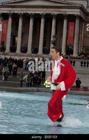 Als Weihnachtsmann verkleidet Santacon 2010, Flashmob Zusammenkunft von Menschen im Zentrum von London. Santa in Trafalgar Square Brunnen Stockfoto