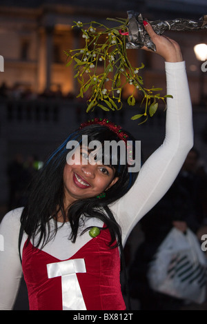 Als Weihnachtsmann verkleidet Santacon 2010, Flashmob Zusammenkunft von Menschen in London. Weibliche Santa auf dem Trafalgar Square unter Mistel Stockfoto