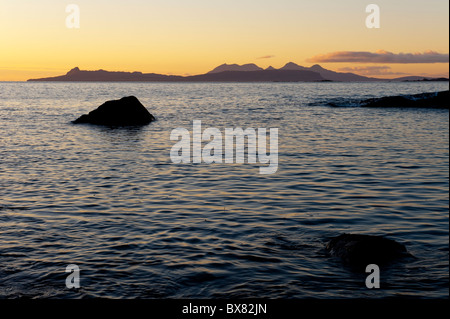 Wunderschön schimmernde Seelandschaft mit Blick auf den schottischen Inseln Rum und Eigg bei Sonnenuntergang erschossen von der Ardnamurchan Stockfoto